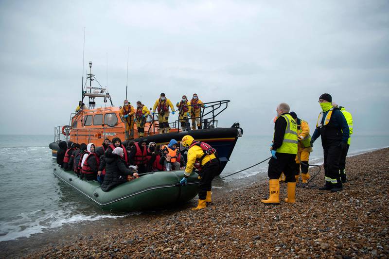 Migrants are helped ashore from a lifeboat at a beach in Dungeness, on the south-east coast of England, on Wednesday after being rescued while crossing the English Channel. AFP