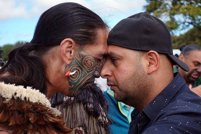 A Muslim man, right, and another local perform a traditional Maori 'hongi' greeting, a touching of noses, during a gathering for congregational Friday prayers and two minutes of silence for victims of the twin mosque massacre, at Hagley Park in Christchurch. AFP
