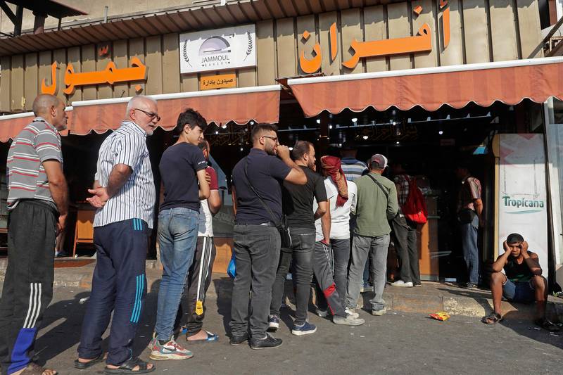 People line up in front of a bakery to buy bread in Lebanon's southern city of Sidon on June 22, 2022 as fuel and wheat shortage deepens. Lebanon has been battered by triple-digit inflation, soaring poverty rates and the collapse of its currency. AFP
