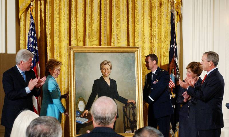 Mr Clinton and then-president George W Bush and his wife Laura, applaud as Mrs Clinton's portrait is unveiled in 2004. AP