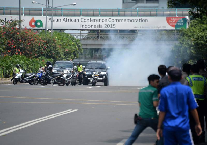 (FILES) This file photo taken on January 14, 2016 shows police (L) hiding behind vehicles during an exchange of gunfire with suspects hiding near a Starbucks coffee shop in Jakarta. Indonesian cleric Aman Abdurrahman was sentenced to death on June 22, 2018 over his role in the 2016 Islamic State terror attack that saw a suicide bomber blow himself up at the Jakarta Starbucks cafe. - 
 / AFP / Bay ISMOYO
