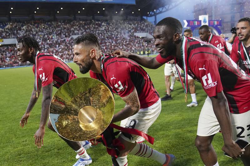 Rafael Leao, left, Olivier Giroud, centre, and Fikayo Tomori celebrate after winning the Serie A title. AP