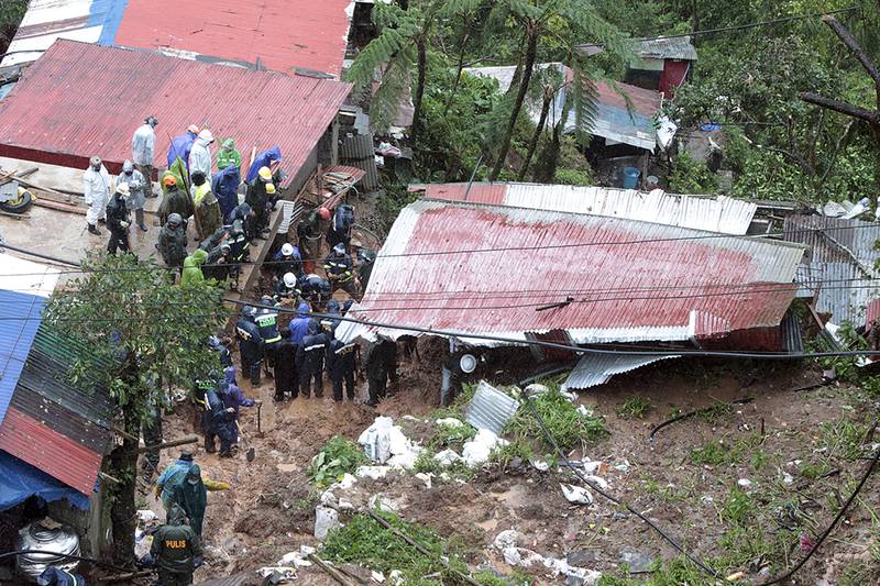 Rescuers search a house buried by a landslide caused by Tropical Cyclone Kompasu in Baguio, northern Philippines, on Tuesday. Photo: AP