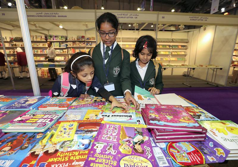 Sharjah, United Arab Emirates - April 18, 2019: Children look at their favourite books at the Sharjah children's reading festival. Thursday the 18th of April 2019. Expo Centre, Sharjah. Chris Whiteoak / The National