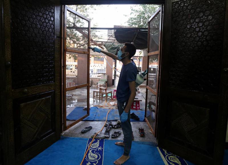 A volunteer disinfects the entrance to a mosque in Cairo.  Reuters