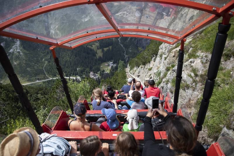Tourists wearing protective face masks take a ride on the 'Gelmerbahn' funicular near the Grimsel pass road above Guttannen in Berne, Switzerland. With an inclination of up to 106 per cent, this funicular is the steepest of its kind in Europe. EPA