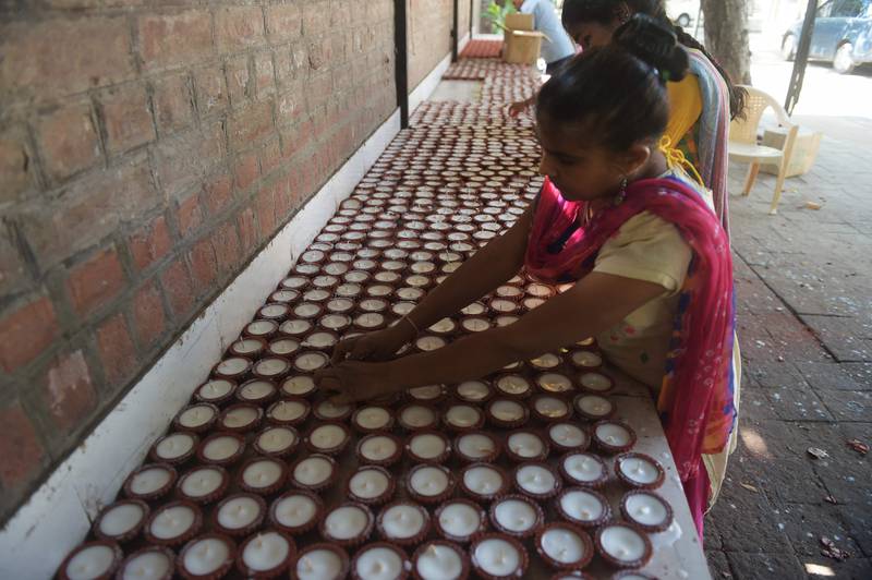 Girls prepare wax-filled earthen lamps ahead of Diwali, at a centre for visually challenged girls in Ahmedabad. AFP