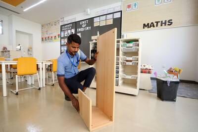 Ashraf prepares new desks in a classroom at the Swiss International Scientific School. Chris Whiteoak / The National