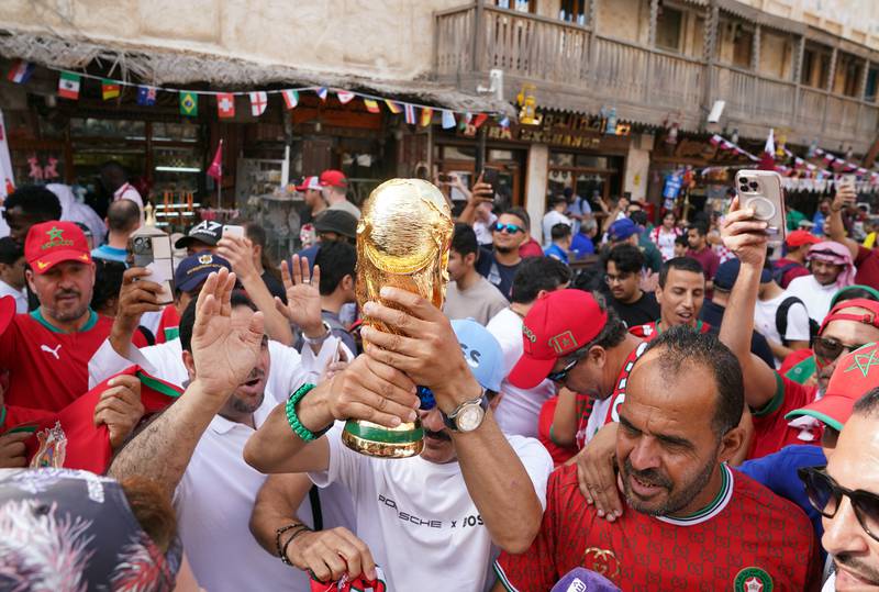 Fans with a replica World Cup Trophy in the Souq Waqif area of Doha. PA