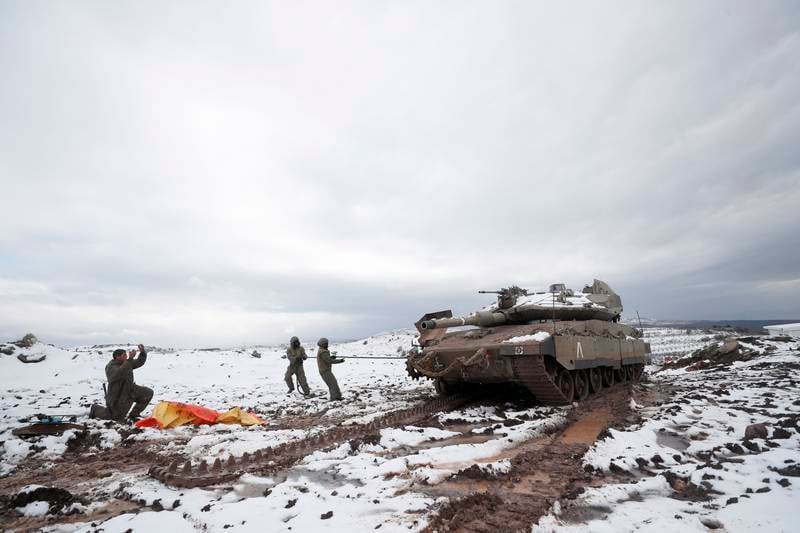 Israeli armored corps soldiers, fix their tank chains during snowstorm near the Israel-Syrian border in the annexed Golan Heights, near the Druze village of Majdal Shams. EPA
