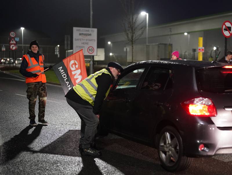 Members of the GMB union try to stop colleagues from entering the plant. PA