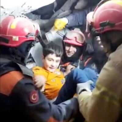 Rescuers with a child pulled out from under the rubble. Reuters