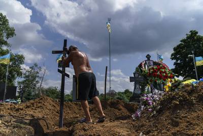 A cemetery worker places a cross on the grave of Ukrainian soldier Serhiy Marchenko, who died aged 26, after his burial in Pokrovsk, Donetsk region. AP 