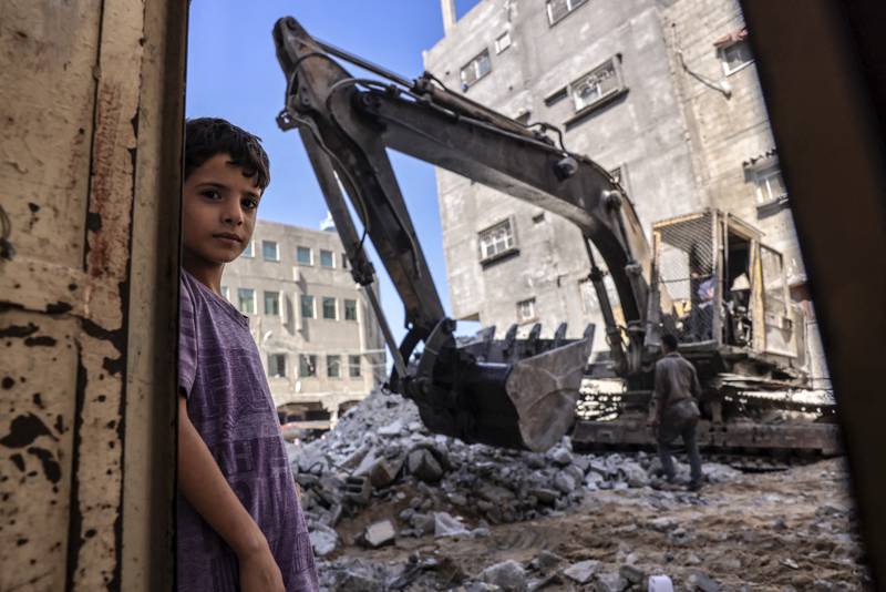 A Palestinian boy looks on as workers clear the rubble of a building destroyed by Israeli bombing last May, in Rafah in the southern Gaza Strip. AFP