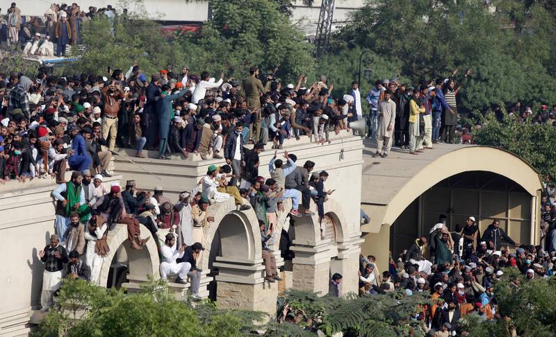 People gather on a building to attend funeral services for Khadim Hussain Rizvi, leader of religious and political party Tehreek-e-Labaik Pakistan (TLP), Lahore. Reuters