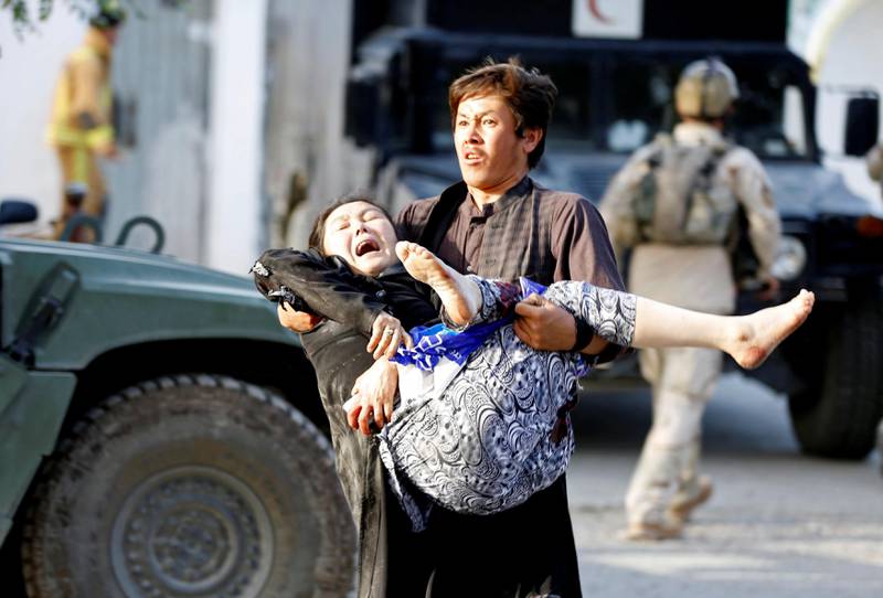 An Afghan man carries an injured woman from the site of a suicide attack followed by a clash between Afghan forces and insurgents after an attack on a Shi'ite Muslim mosque in Kabul, Afghanistan, August 25, 2017. REUTERS/Omar Sobhani