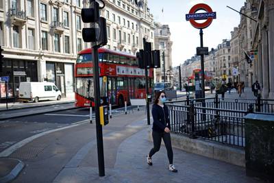 A pedestrian wearing a face covering walks past shops on the almost empty Oxford Circus in central London. AFP