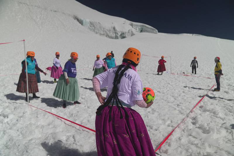 Aymara indigenous women members of the Climbing Cholitas play a football match on the last flat area before heading for the summit.