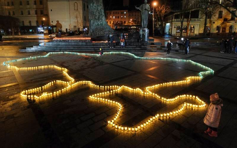 Ukrainians light candles to form a map of the country on the central square of the city of Lviv, in memory of innocent civilians killed since the Russian invasion.  EPA