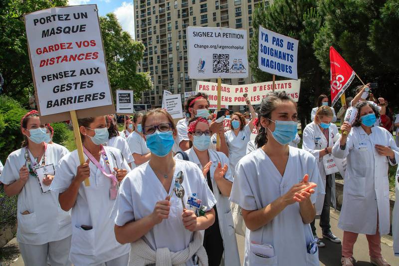 Medical personnel from the Robert Debre hospital wear masks to help curb the spread of the coronavirus stage a protest in Paris, Thursday, June 11, 2020. French nurses and doctors demand better pay and a rethink of a once-renowned public health system that found itself quickly overwhelmed by tens of thousands of virus patients. (AP Photo/Michel Euler)