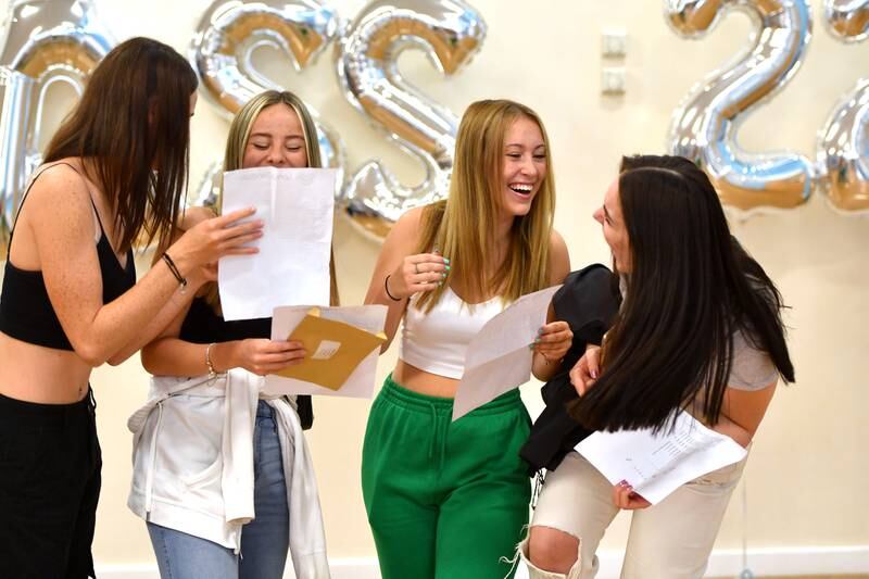From left; Freya White, Megan Brough, Isabella Chisnall and Meagan Littlewood smile as they receive their GCSE results at Longdendale High School in Hyde, Greater Manchester. Getty Images
