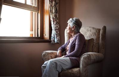 Shot of a senior woman sitting alone in her living room. Getty Images