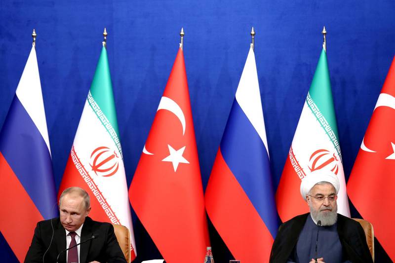 Iran's President Hassan Rouhani, right, speaks in a joint press conference with Russia's President Vladimir Putin, left, and Turkey's President Recep Tayyip Erdogan in Tehran, Iran, Friday, Sept. 7, 2018. Putin, Erdogan and Iran's President Hassan Rouhani began a meeting Friday in Tehran to discuss the war in Syria, with all eyes on a possible military offensive to retake the last rebel-held bastion of Idlib. (AP Photo/Ebrahim Noroozi)