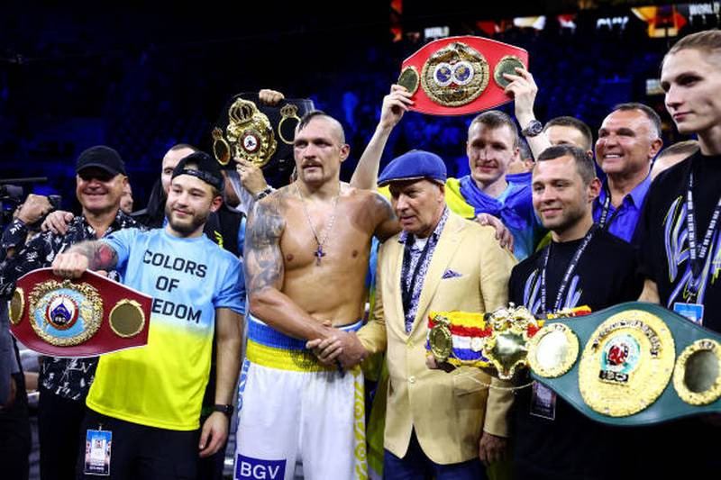 Oleksandr Usyk celebrates with his belts and his team. Getty