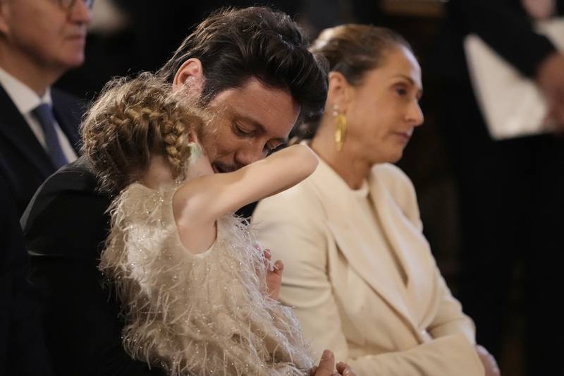 Husband to newly appointed Prime Minister Giorgia Meloni, Andrea Giambruno, holds in his arm their daughter Ginevra, flanked by sister Arianna Meloni. AP 