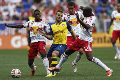 Arsenal's Jack Wilshere dribbles through New York Red Bulls players, from left to right, Ambroise Oyongo, Tim Cahill and Ibrahim Sekagya during their friendly on Saturday. Jeff Zelevansky / Getty Images/  AFP