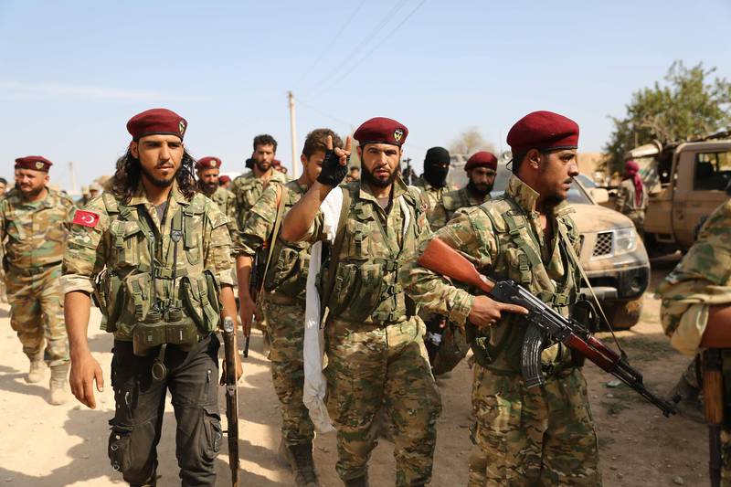 Turkey-backed Syrian fighters gather on the outskirts of the key Syrian border town of Ras al-Ain on October 16, 2019 during the ongoing assault by Turkey and its allies on Kurdish-held border towns in northeastern Syria. Turkey rebuffed international pressure to curb its military offensive against Kurdish militants in Syria today as US President Donald Trump dispatched his deputy Mike Pence to Ankara to demand a ceasefire. / AFP / Nazeer Al-khatib
