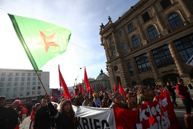 Demonstrators hold banners and wave flags at a protest against the annual security conference in Munich, Germany. REUTERS