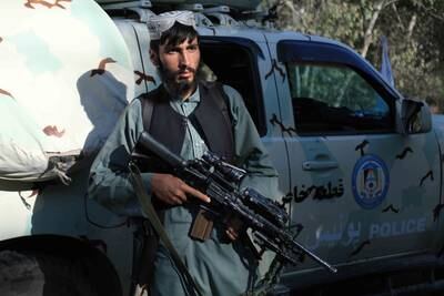 Taliban fighters use a captured Afghan security forces vehicle at a checkpoint in Herat.