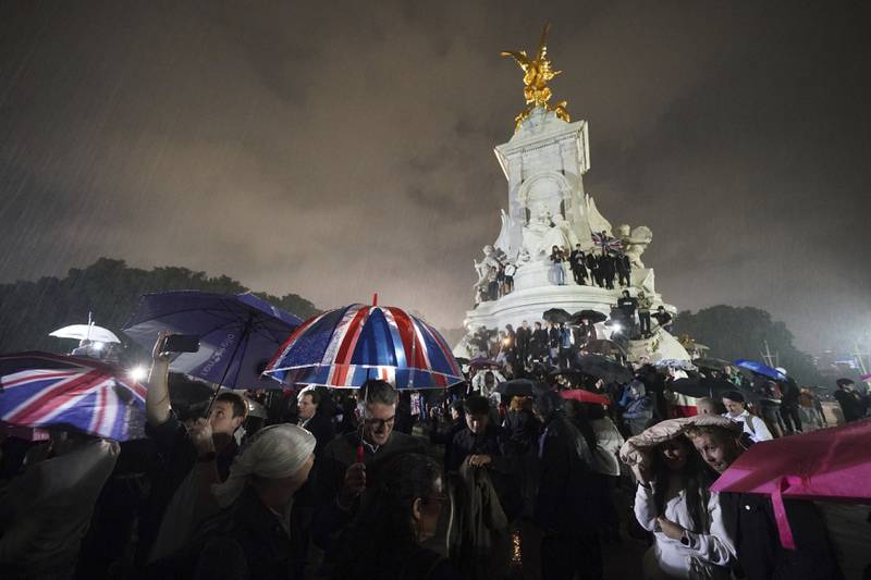 People gather at the Queen Victoria Memorial opposite Buckingham Palace after the death of Queen Elizabeth II. PA