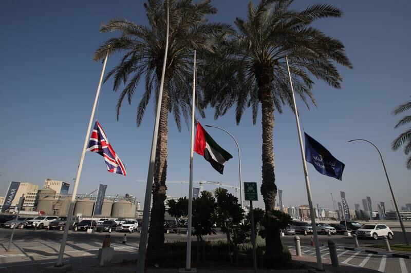 A British national flag, left, and the Emirati flag, centre, fly at half-mast during the mourning period and in honour of Queen Elizabeth II. EPA
