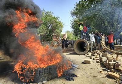 Sudanese protesters burn tyres as they block Nile Street for the second consecutive day during continuing protests in Sudan's capital Khartoum on May 13, 2019. - While angry demonstrators blocked the major avenue along the Nile river, Sudan's army rulers and protest leaders resumed crucial talks over handing power to a civilian administration after a deadlock in negotiations. The much-awaited discussions came with crowds of protesters still camped round-the-clock outside the army headquarters in central Khartoum, vowing to force the ruling military council to cede power -- just as they drove longtime leader Omar al-Bashir from office on April 11. (Photo by ASHRAF SHAZLY / AFP)