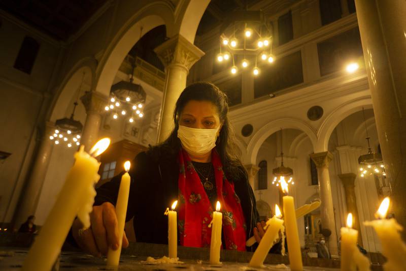 An Egyptian worshipper lights candles during Christmas Eve Mass at Saint Joseph Catholic Church in Cairo. AP