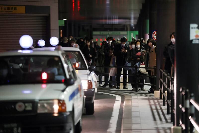 People queue for taxis at Sendai station after train services from the city were suspended. EPA