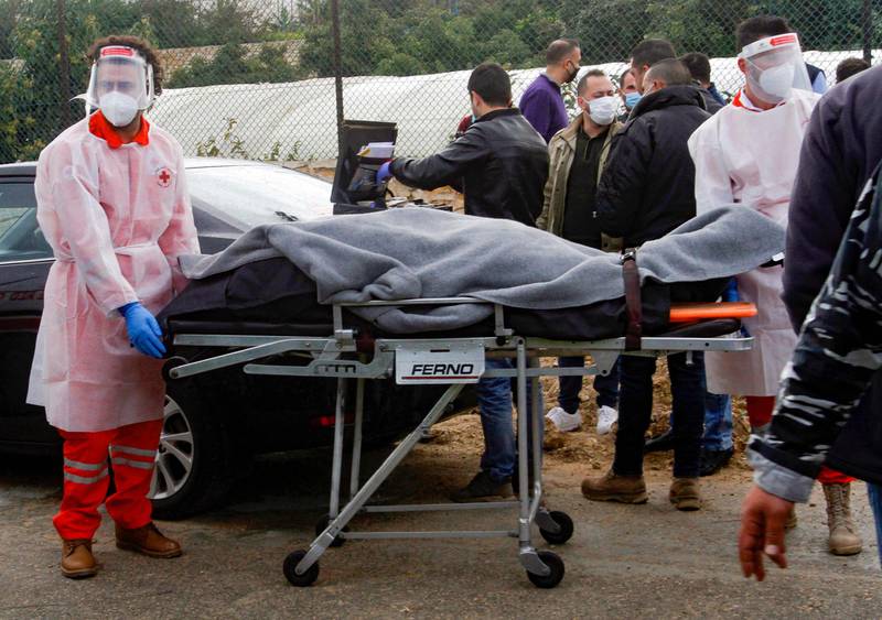 Medics wheel away the body of Lokman Slim from the car in which he was found dead in southern Lebanon. AFP