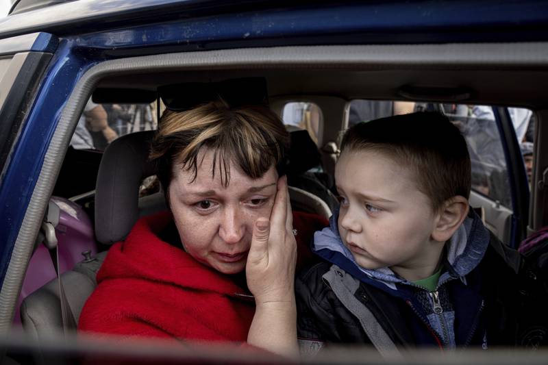 Natalia Pototska, 43, cries as her grandson Matviy looks on in Zaporizhzhia. AP