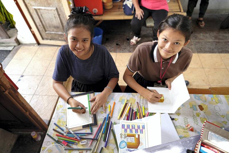 Bangkok-Thailand-CLC (Community Learning Center) Temple of Dawn- After finished of her duty come to a relax time, One of assistance nurse CLC’s Student accompany Som (Junior Student) to make the drawing together. Sasamon Rattanalangkarn for The National
