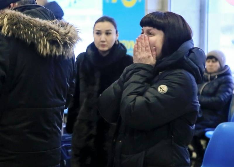 Relatives and friends of those on the Saratov Airlines airline plane An-148 flight that crashed near Moscow's airport Domodedovo react while gathering at an airport outside Orsk, Russia. Orsk.ru via AP