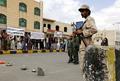 epa05242653 A Yemeni soldier (R) keeps watch as Baha'i Faith members hold banners during a protest against the trial of member of the Baha'i Faith Hamed Haydara, outside the state security court in Sana?a, Yemen, 03 April 2016. According to reports, Yemeni authorities have indicted Hamed Haydara, a Yemeni national who was detained in December 2013 accused of being a spy for Israel and converting Muslims to the Baha'i Faith.  EPA/YAHYA ARHAB