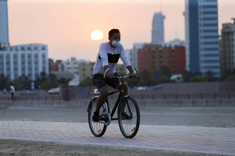 A cyclist wearing a protective face mask rides his bike during sunset in Manama, Bahrain. Reuters
