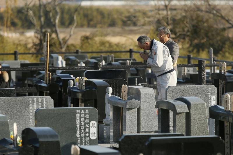 Relatives pray at a cemetery for victims of the 2011 Great East Japan earthquake on the seventh anniversary of the disaster in Namie, Fukushima prefecture, Japan, on March 11, 2018. Jiji Press / AFP