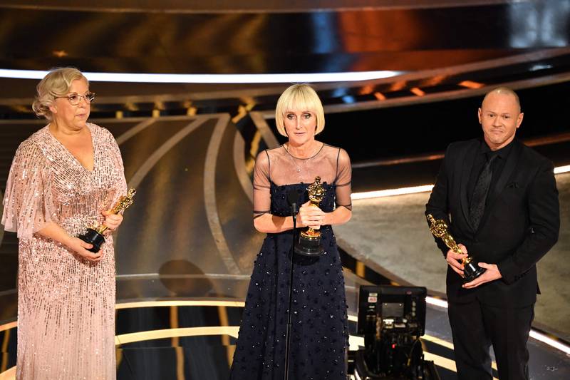 The makeup and hairstyling team for 'The Eyes of Tammy Faye' Linda Dowds, centre, Stephanie Ingram, left, and Justin Raleigh accepts the Best Makeup and Hairstyling Award at Oscars 2022. AFP