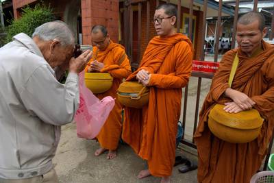 A Thai man prays to Buddhist monks. AFP