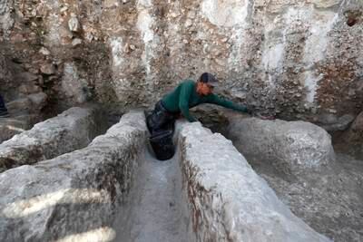 An employee of the Israel Antiquities Authority works at a channel installation found in the City of David National Park, Jerusalem. EPA