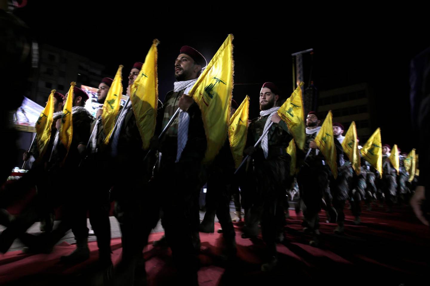 FILE - In this May 31, 2019 file photo, Hezbollah fighters march at a rally to mark Jerusalem day or Al-Quds day, in the southern Beirut suburb of Dahiyeh, Lebanon. An economic meltdown, a revolution, financial collapse, a virus outbreak and a cataclysmic explosion that virtually wiped out the country's main port. The past year has been nothing short of an earthquake for tiny Lebanon, with an economic meltdown, mass protests, financial collapse, a virus outbreak and a cataclysmic explosion that virtually wiped out the countryâ€™s main port. Yet Lebanese fear even darker days are ahead. (AP Photo/Hassan Ammar, File)
