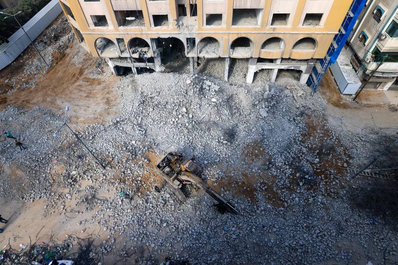 Palestinian workers clear the rubble of Al Jawhara Tower in Gaza City's Al Rimal neighbourhood. AFP